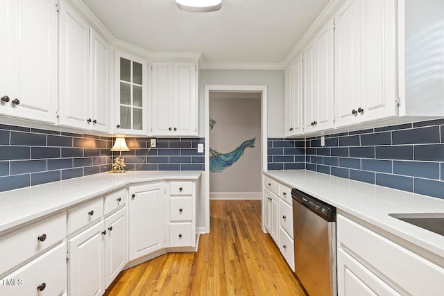 kitchen featuring stainless steel dishwasher, crown molding, light hardwood / wood-style floors, decorative backsplash, and white cabinets