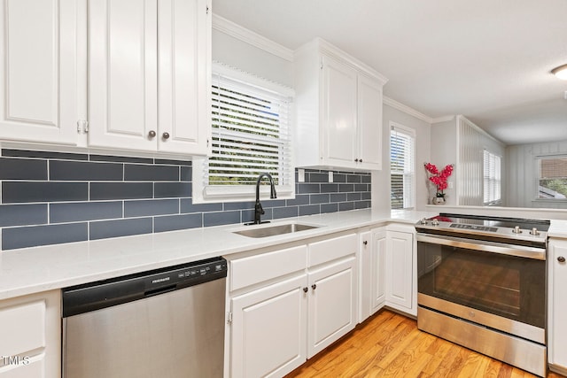 kitchen with white cabinets, appliances with stainless steel finishes, plenty of natural light, and sink