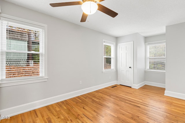 empty room featuring a textured ceiling, light hardwood / wood-style flooring, and ceiling fan