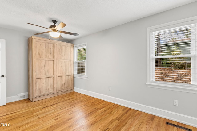 unfurnished bedroom with ceiling fan, light hardwood / wood-style flooring, and a textured ceiling