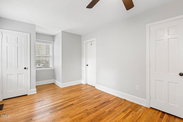 unfurnished bedroom with ceiling fan, light hardwood / wood-style floors, and a textured ceiling