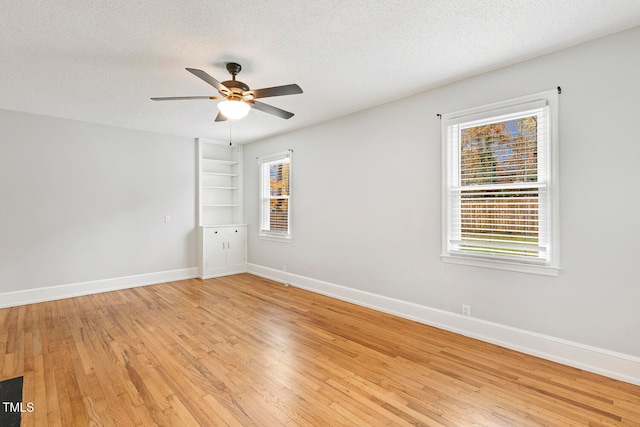 unfurnished room featuring a textured ceiling, light hardwood / wood-style flooring, and ceiling fan