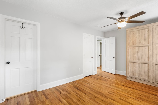 unfurnished bedroom with hardwood / wood-style flooring, ceiling fan, and a textured ceiling