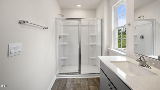 bathroom with hardwood / wood-style flooring, a shower with door, and vanity