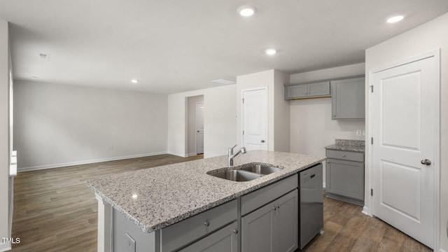 kitchen with dark hardwood / wood-style flooring, gray cabinets, sink, an island with sink, and stainless steel dishwasher