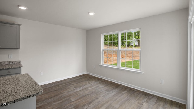 unfurnished dining area with dark wood-type flooring