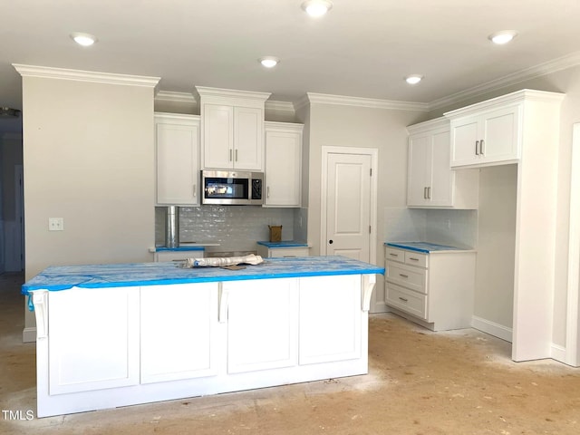 kitchen with white cabinets, tasteful backsplash, and ornamental molding