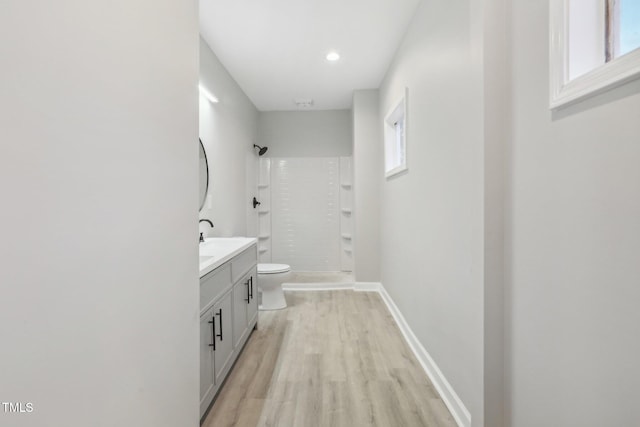 bathroom featuring walk in shower, toilet, hardwood / wood-style flooring, and a healthy amount of sunlight