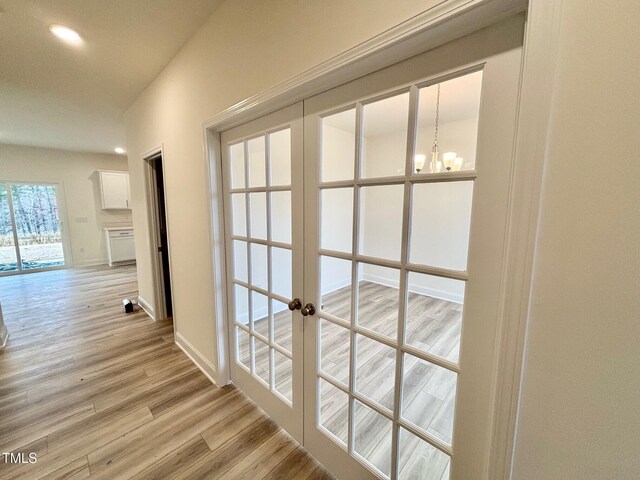 hallway with a chandelier and light hardwood / wood-style flooring