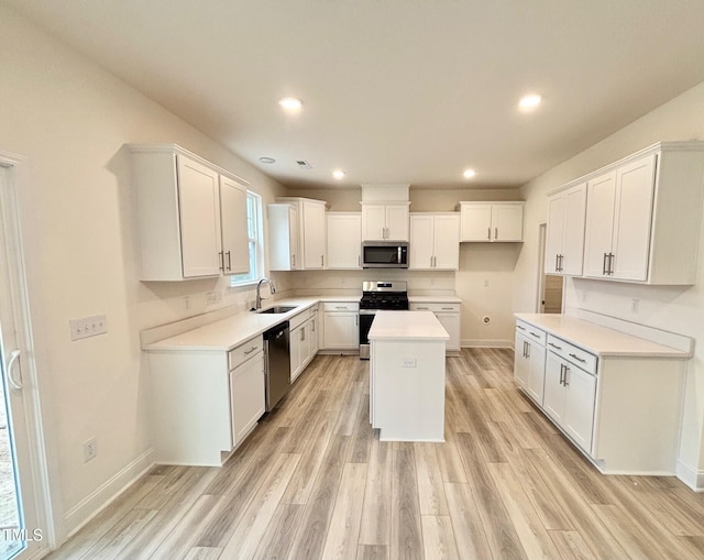 kitchen featuring sink, a kitchen island, light hardwood / wood-style floors, white cabinetry, and stainless steel appliances