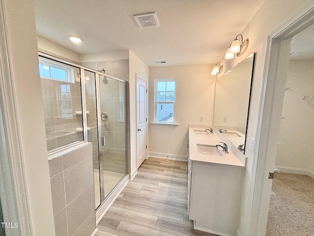 bathroom featuring a shower with door, vanity, and hardwood / wood-style floors