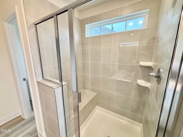 bathroom with hardwood / wood-style floors and a shower with shower door