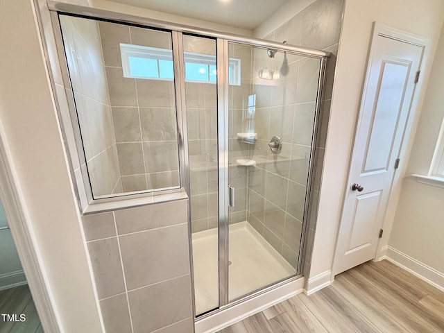 bathroom featuring wood-type flooring and a shower with door