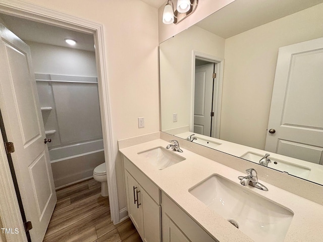 bathroom with wood-type flooring, vanity, and toilet