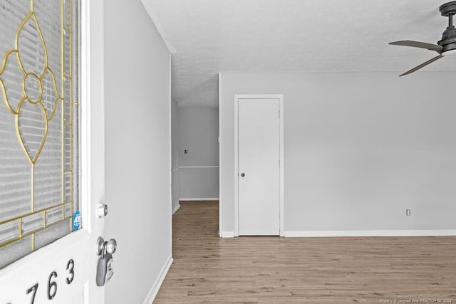 interior space with ceiling fan, a textured ceiling, and light hardwood / wood-style floors