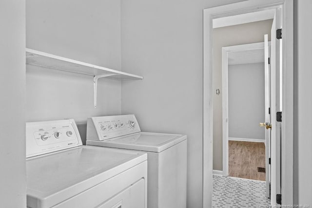 clothes washing area featuring washing machine and dryer and light hardwood / wood-style floors