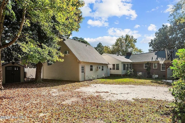 back of property with a storage shed