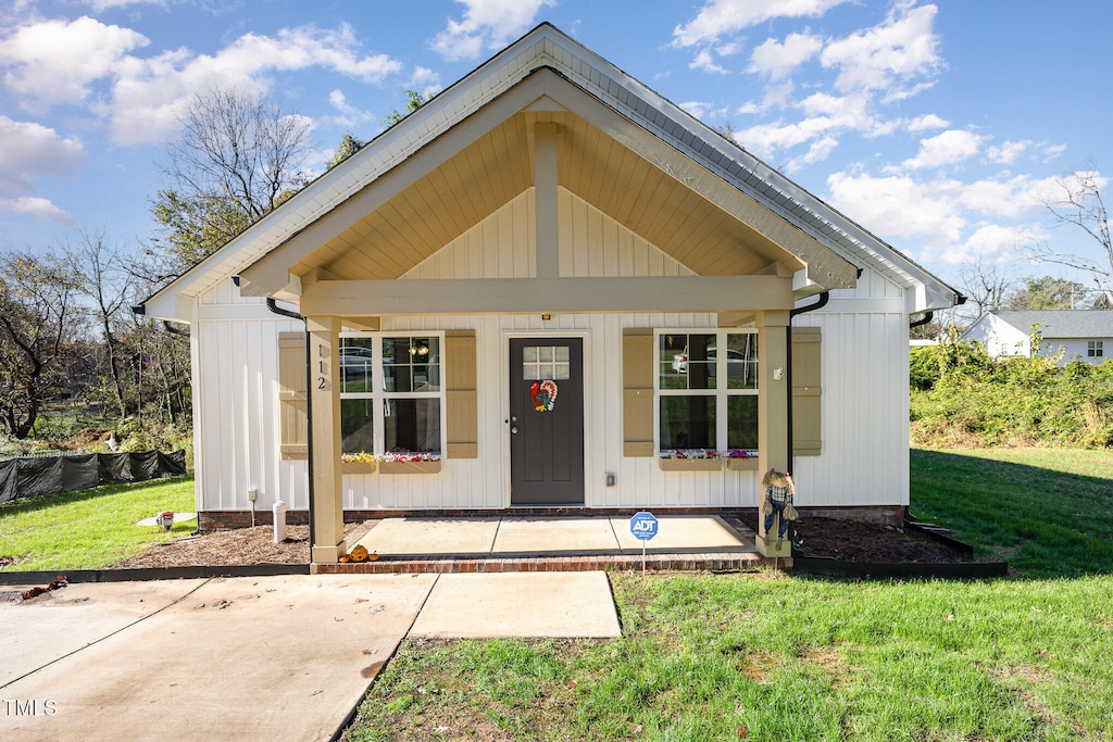 view of front of house with a porch and a front yard