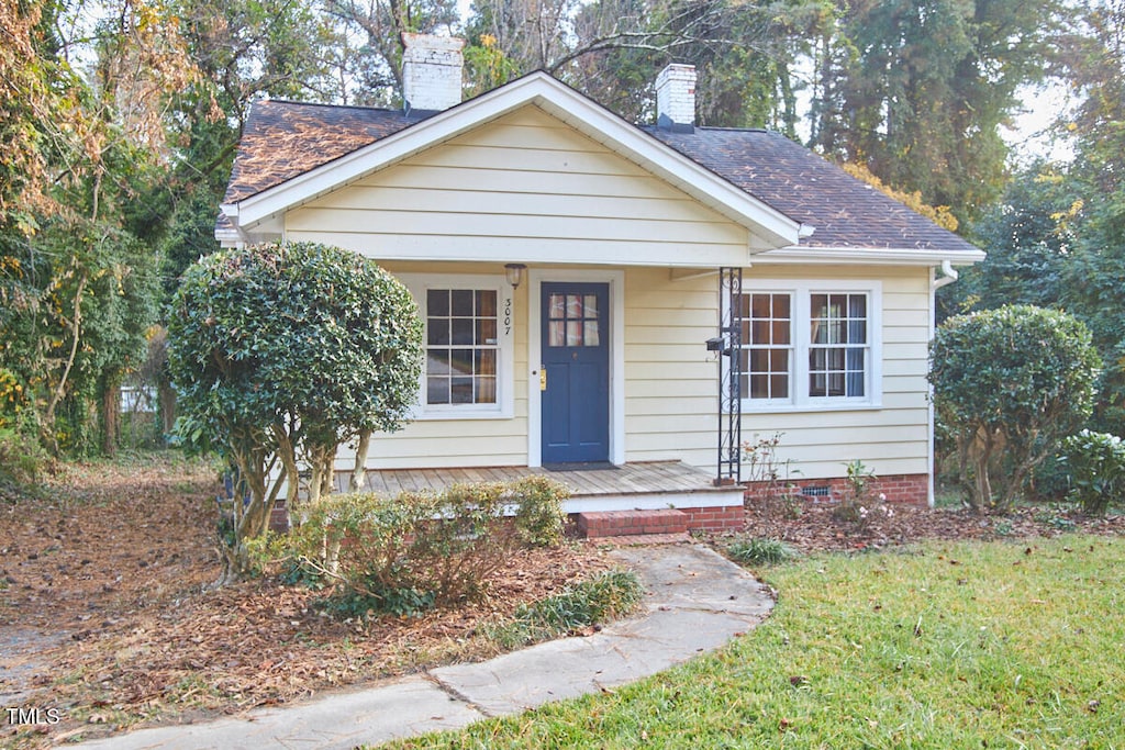 bungalow-style home with a front lawn