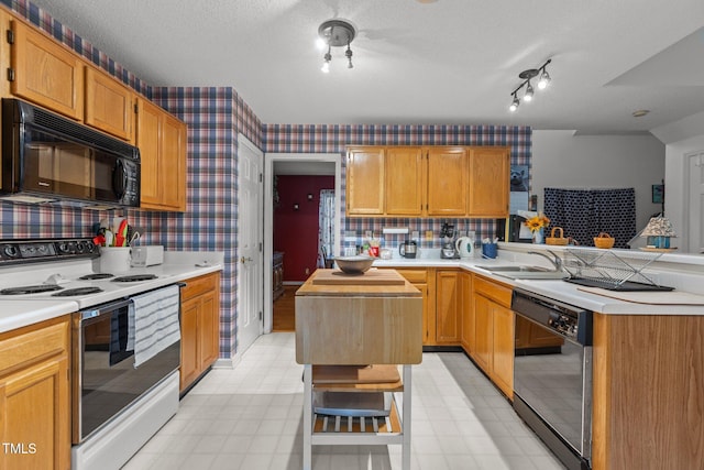 kitchen featuring sink, a center island, tasteful backsplash, a textured ceiling, and black appliances