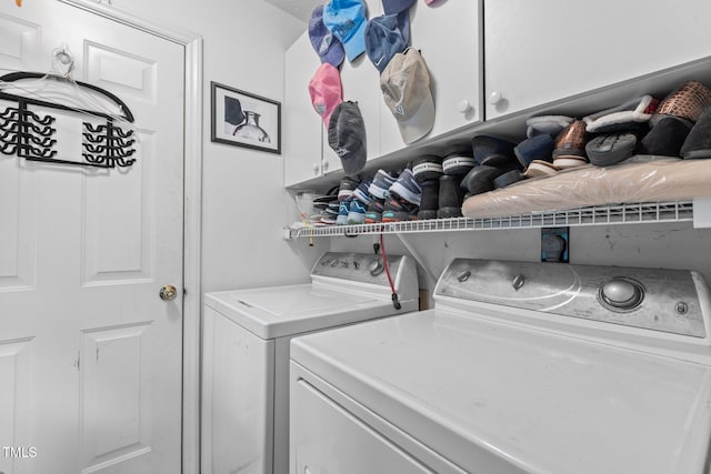 clothes washing area with cabinets and washing machine and dryer