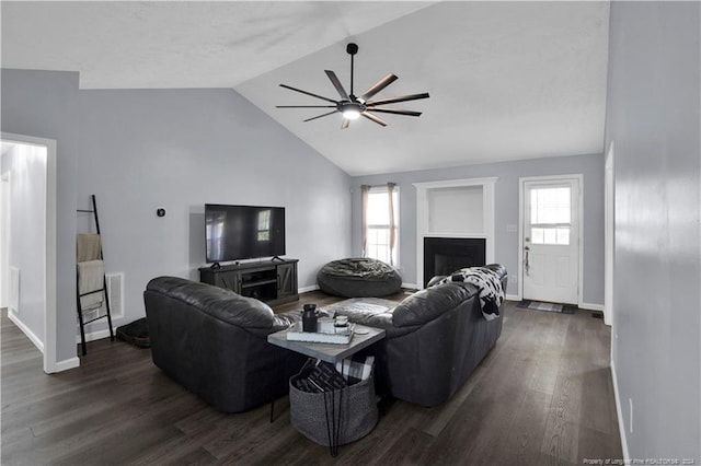 living room featuring dark hardwood / wood-style flooring, ceiling fan, and vaulted ceiling