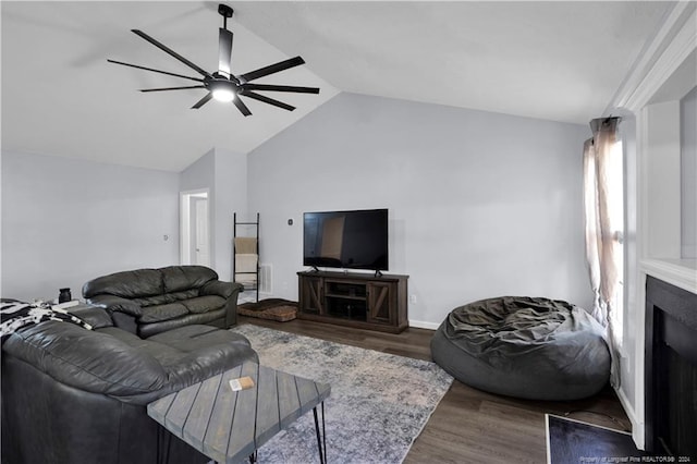 living room featuring vaulted ceiling, hardwood / wood-style flooring, ceiling fan, and a fireplace