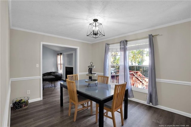 dining room with ornamental molding, dark wood-type flooring, a textured ceiling, and a chandelier