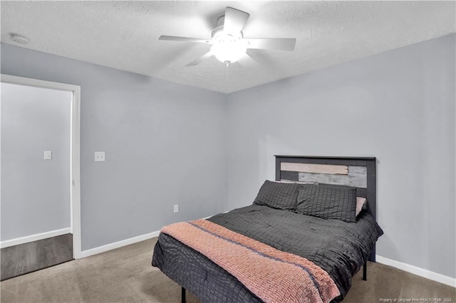 bedroom featuring a textured ceiling, light carpet, and ceiling fan