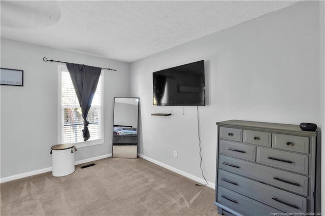 unfurnished bedroom with light colored carpet and a textured ceiling