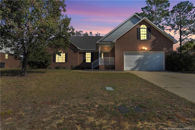 traditional-style house with concrete driveway, a yard, brick siding, and an attached garage