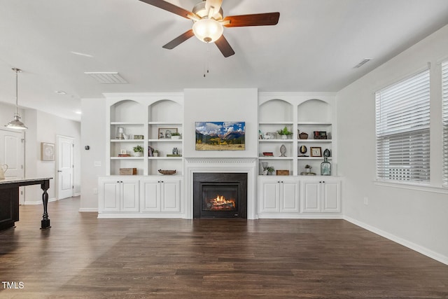 living room featuring dark hardwood / wood-style floors, ceiling fan, and built in shelves