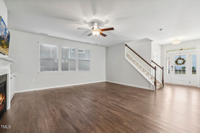 unfurnished living room featuring ceiling fan and dark hardwood / wood-style flooring