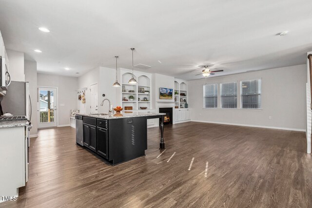 kitchen with appliances with stainless steel finishes, ceiling fan, sink, pendant lighting, and a center island with sink