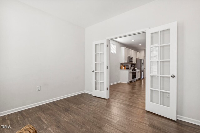 spare room featuring dark wood-type flooring and french doors