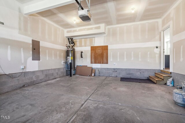 garage featuring electric panel, water heater, and a garage door opener