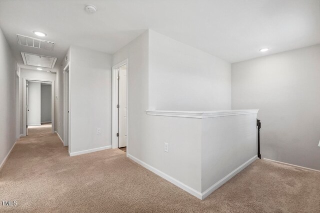 corridor featuring light colored carpet