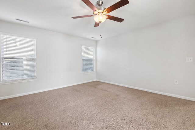 carpeted spare room with ceiling fan