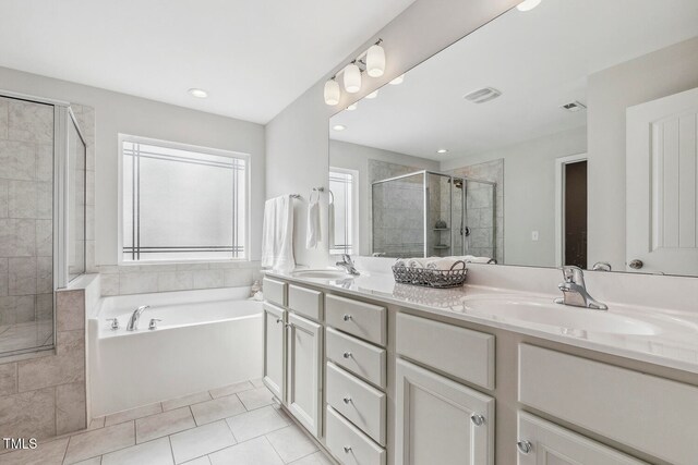 bathroom featuring tile patterned flooring, shower with separate bathtub, and vanity