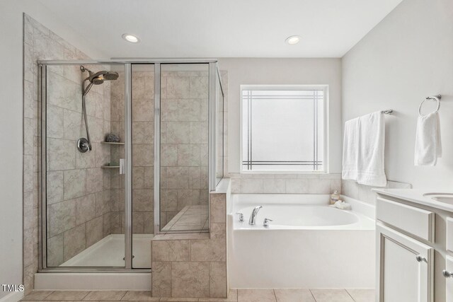 bathroom featuring tile patterned floors, vanity, and plus walk in shower