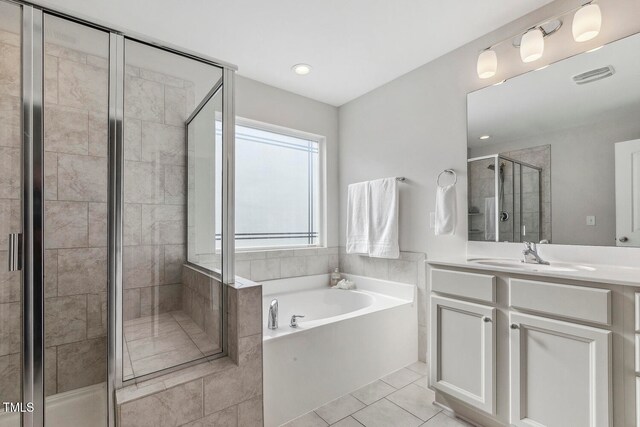 bathroom featuring tile patterned flooring, shower with separate bathtub, and vanity