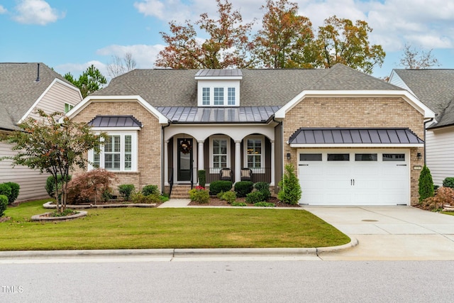 view of front of home with a garage, covered porch, and a front lawn