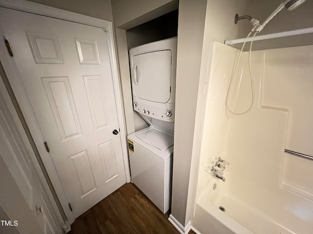 washroom with dark wood-type flooring and stacked washer and clothes dryer