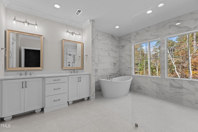 bathroom with vanity, tile patterned floors, a bathtub, and tile walls