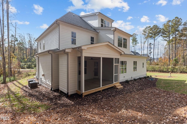 back of property with central AC unit and a sunroom