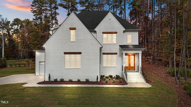 2105 Gentry Rd, Wake Forest, NC 27587 - view of front of home featuring brick siding, a lawn, a standing seam roof, and metal roof