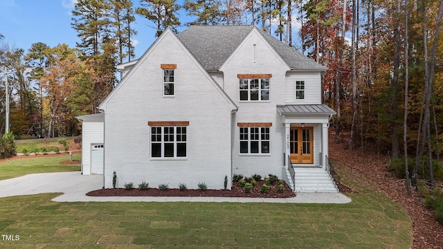 2105 Gentry Rd, Wake Forest, NC 27587 - view of front of property featuring brick siding, a front lawn, a shingled roof, a standing seam roof, and concrete driveway