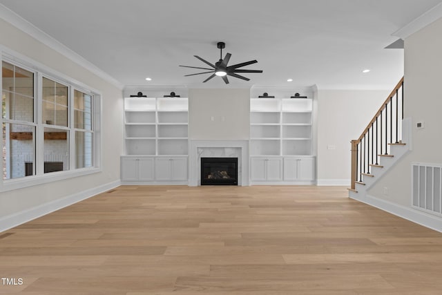 unfurnished living room with a fireplace, light hardwood / wood-style floors, ceiling fan, and ornamental molding