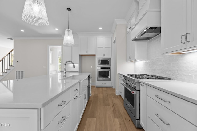 2105 Gentry Rd, Wake Forest, NC 27587 - kitchen featuring stainless steel appliances, premium range hood, light countertops, a sink, and white cabinetry