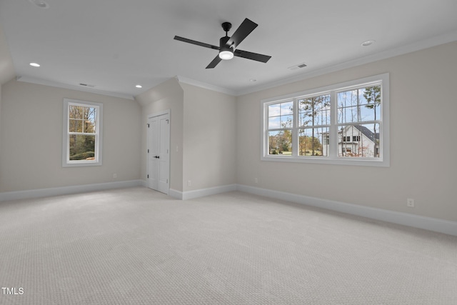 interior space with multiple windows, light colored carpet, ceiling fan, and crown molding